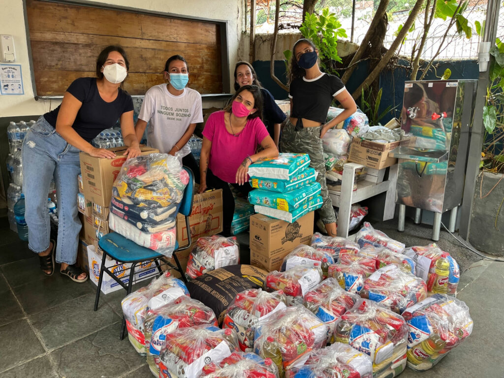 Fotografia com grupo de mulheres do coletivo e a Rosa com as doações
